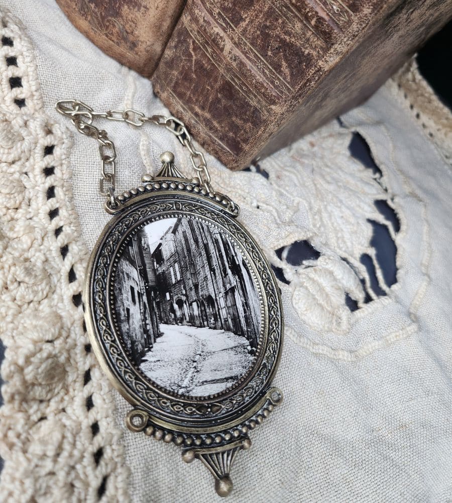 Un ancien médaillon avec chainette, photo d'une ruelle