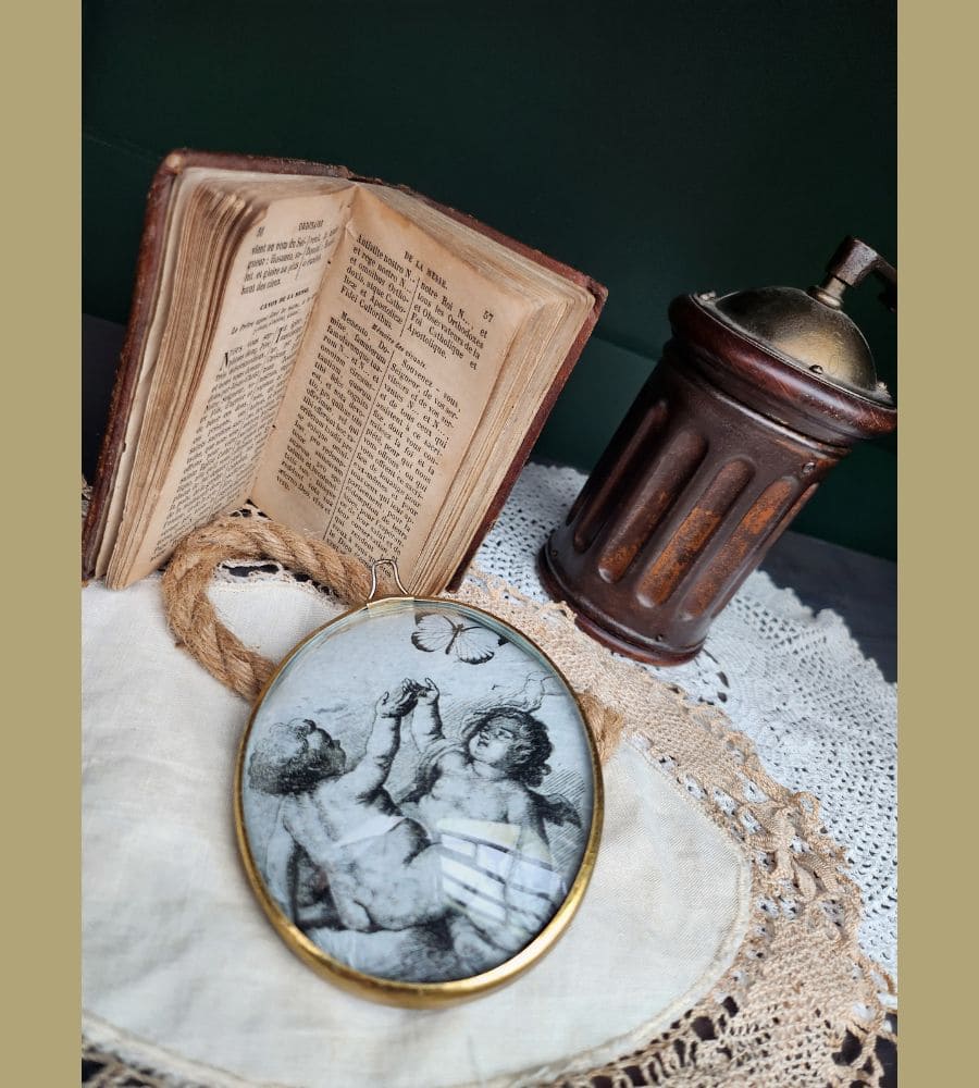 Un ancien médaillon avec son verre bombé motif anges